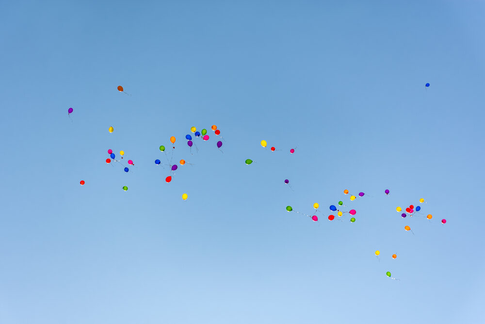 Bunte Luftballons steigen in einen blauen Himmel